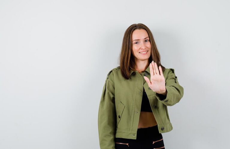 Lächelnde Frau, die die Handfläche nach vorne hält.